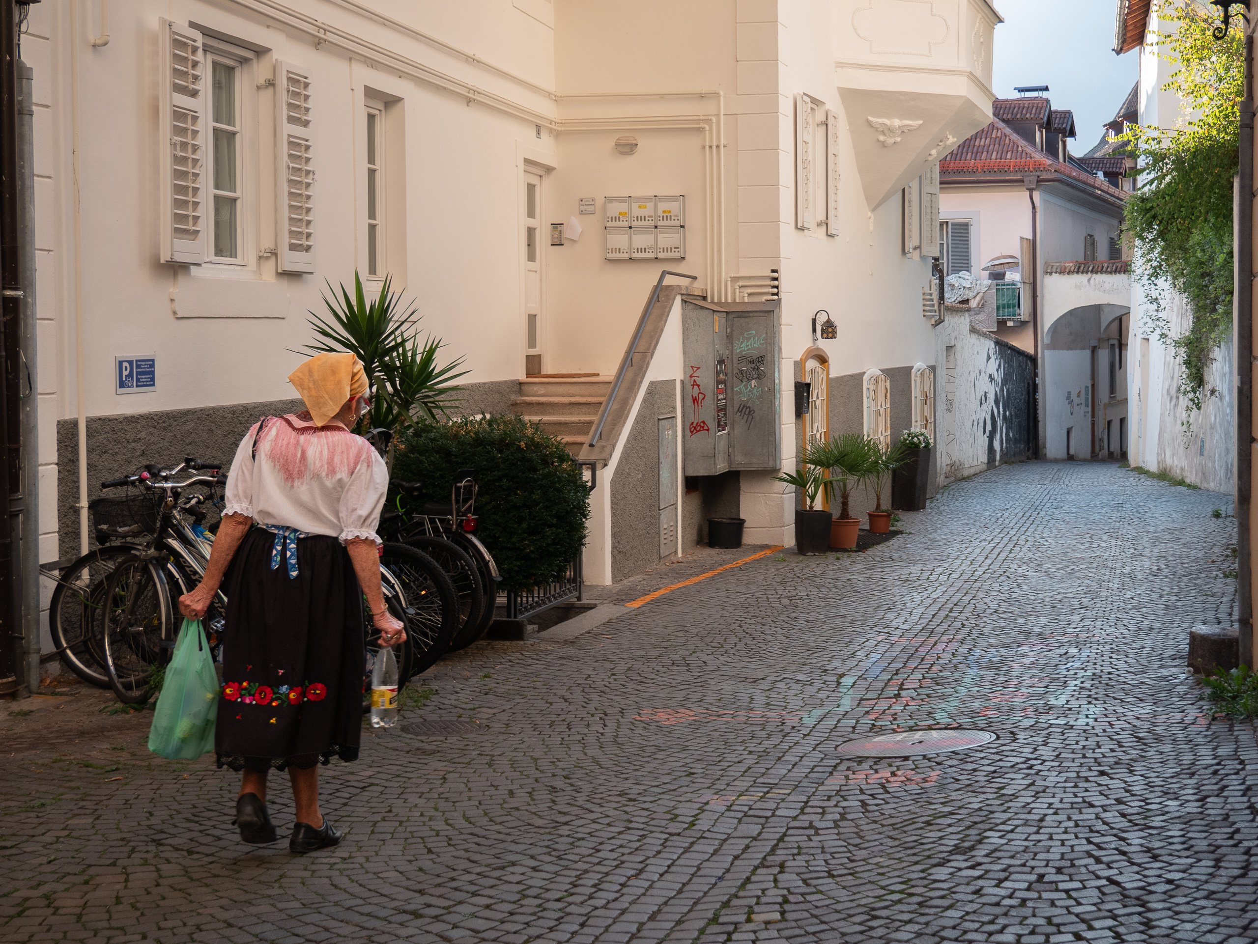 Frau in Südtiroler Tracht in einer Gasse von Meran